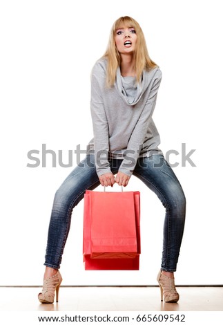 Buying retail sale concept. Fashionable girl denim pants high heels with red shopping bags isolated on white