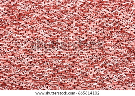The texture of a knitted woolen fabric in pink, red and white color. Natural background. 