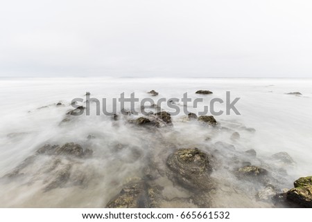 Foggy pacific ocean tidal pool with motion blur at Point Dume in Malibu California.