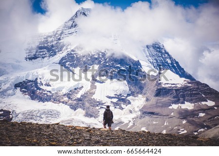 Man versus mountain. 
Man staring in awe of a mountain.  Royalty-Free Stock Photo #665664424