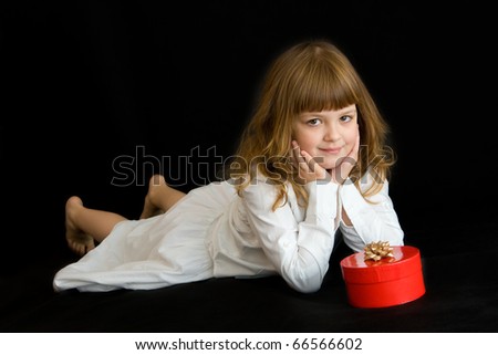 little girl with red present on black background
