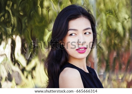Asian young woman against the mirror wall outdoors