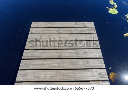 reflection of clouds in the lake with boardwalk and trees in background