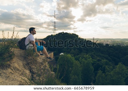 man sitting on the peak alone with his minds, clody wheather