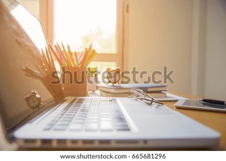 Laptop with financial documents on wooden table