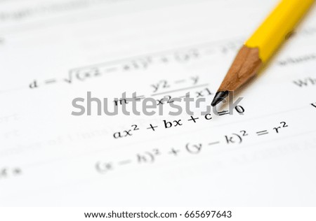 pencil and a white piece of paper with mathematical problems