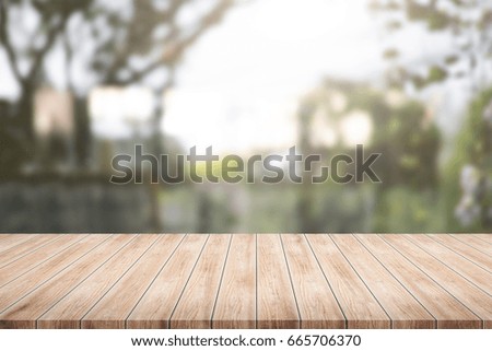 Wood table top on blurred green plant and garden background - Used for montage or display your products