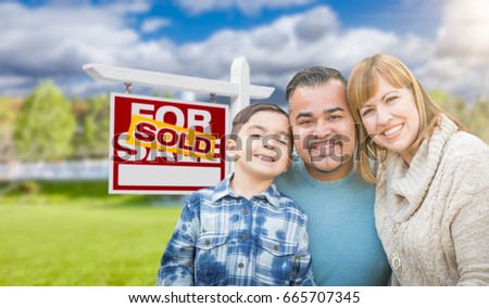 Mixed Race Family In Front of House and Sold For Sale Real Estate Sign