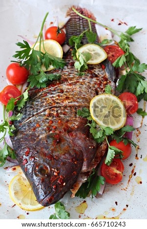 Amnon baked fish with olive oil, parsley, coriander, cherry tomatoes, purple onion and lemon slices 