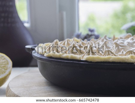 Homemade Lemon Meringue pie on a wooden table.