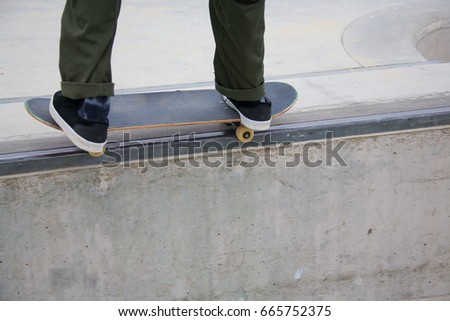 Male doing rail grind while skateboarding at Venice Skate Park in Venice Beach California.