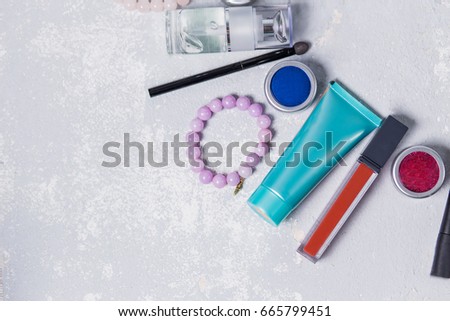 professional makeup closeup on white gray background, primer, toner, cream, red lipstick, eyeshadow, bracelets, makeup, makeover, Studio