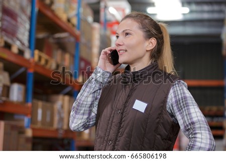 woman talking by mobile phone while holding clipboard