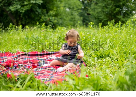Baby playing in nature on plaid blanket