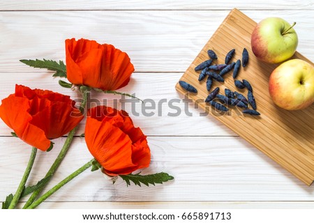 Three poppies on a wooden background. Place for the text.