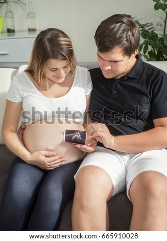 Happy pregnant couple looking on ultrasound baby scan