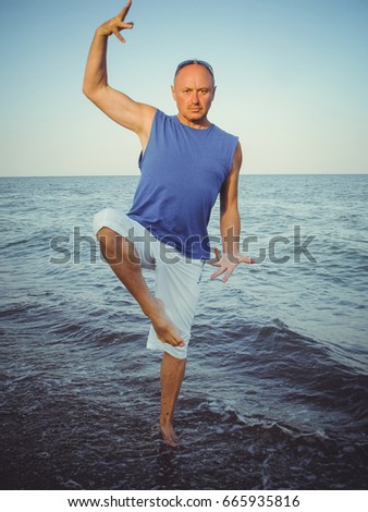 Mature funny American  man  is resting on the beach in the evening and having fun