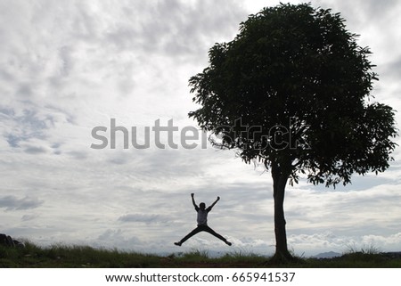 A big tree and jumping kid