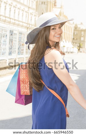 Close up of happy woman with shopping bags. Young cheerful woman holding shopping bags. Beautiful girl with walking in a city center.