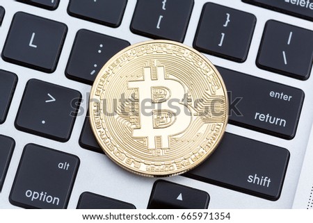 Cryptocurrency physical gold bitcoin coin on the keyboard. Hi res photo.