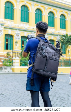 Man tourist taking pictures of landmarks by DSLR camera