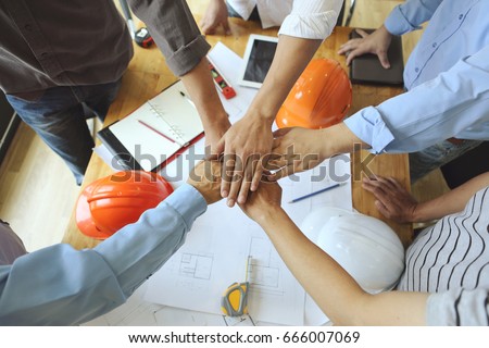 Work Group of Gngineer  people joining hands.(tool ,paper and Safety Helmet) Royalty-Free Stock Photo #666007069