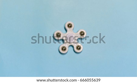 Fidget SPINNER stress relieving toy on blue background.