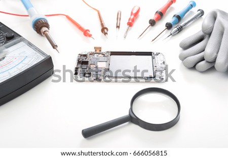 Repaired smartphone with tools on white background
