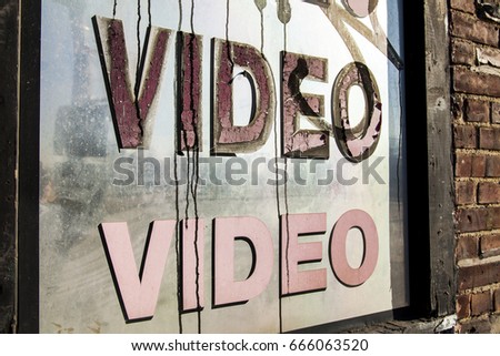 Neglected video store window with graffiti on it.