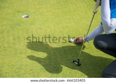 Golfer mark ball on green before putt golf-ball