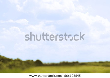 View of green pasture interspersed with blue sky. The picture was blurred.