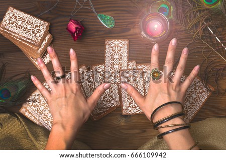 Fortune teller female hands and tarot cards on wooden table. Fortune teller. Royalty-Free Stock Photo #666109942