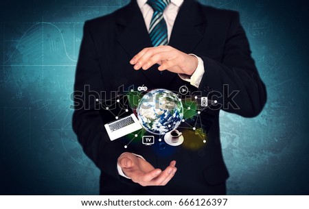 A successful businessman has control over the world concept holding planet earth, laptop in his hand with graph curves in the background. Elements of this image furnished by NASA.