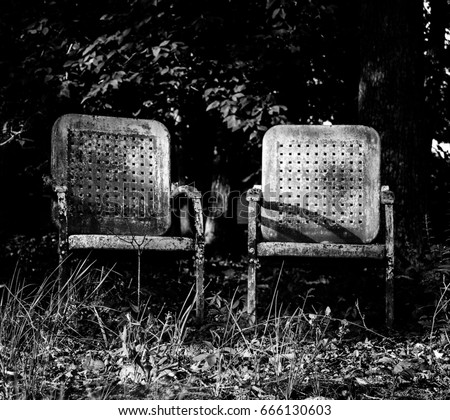 Old chairs looking out on a lake.