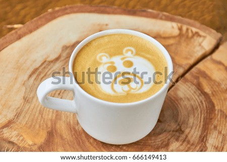Bear coffee foam art. White cup with latte.