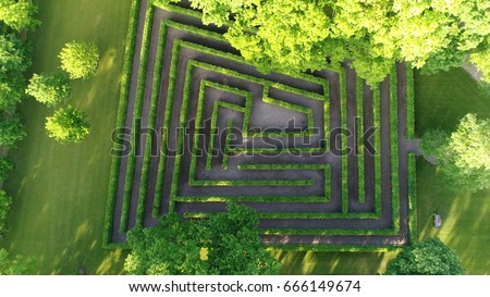 Aerial photo medium altitude above bush maze showing different paths just one leading to exit also known as labyrinth is path or collection of paths typically from entrance to goal drone top-down view Royalty-Free Stock Photo #666149674