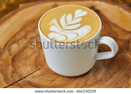 Latte cup with flower art. Coffee foam picture.
