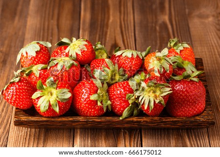 Picture of fresh ripe strawberry on wooden plate close up