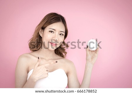 Young beautiful korea woman present product in hand at pink background, 20-30 year old.