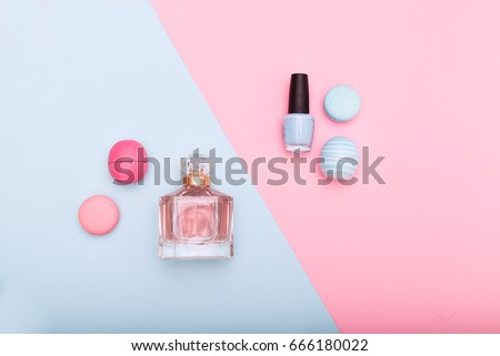 cosmetics and macarons on blue and pink background
