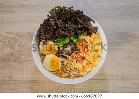 Thai noodle (Asian ramen) with eggs and mushroom and vegetable and tofu in a bowl on wood background