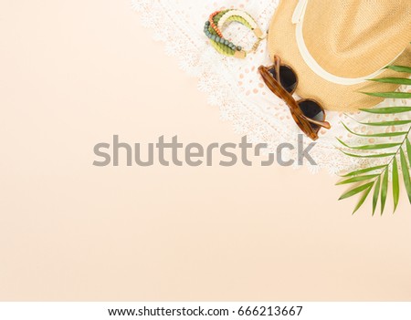 Summer fashion, summer stuff on cream background. White lace dress, retro sunglasses, wood bracelet and straw hat. Flat lay, top view.