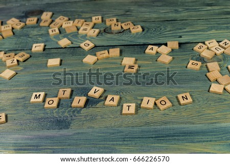Wooden tileswith MOTIVATION text on bright wooden background. Top view