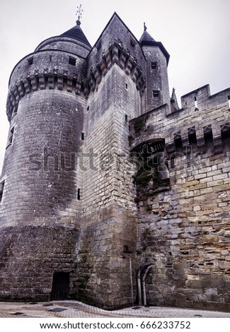 Chateau de Langeais, France. This medieval castle is a landmark of the Loire Valley. Vertical view of the vintage French castle. Strong tower of the old dark castle close-up.