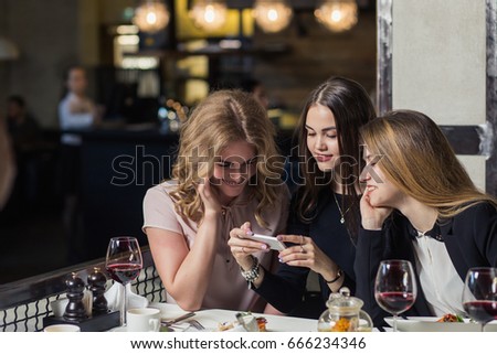friends using smartphones to take photos of sausage and pork chop and beer.