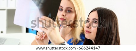 Group of beautiful female doctors hold in hand and look at xray photography to detect problem. Bone disease exam, medic assistance, cancer aid, healthy lifestyle, ill test, hospital practice concept