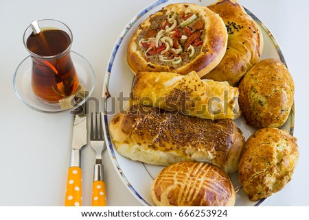 Traditional Turkish pastry,patty various for breakfast with tea on white surface with cutlery set,top view