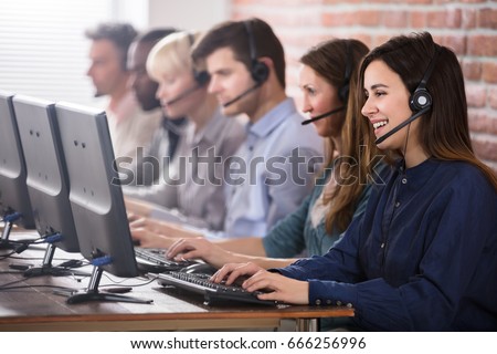 Positive Female Customer Services Agent With Headset Working In A Call Center Royalty-Free Stock Photo #666256996