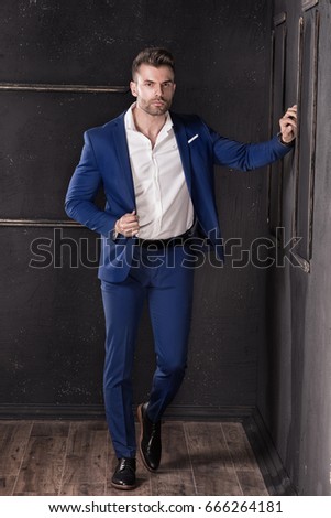 Elegant handsome man posing in fashionable suit.