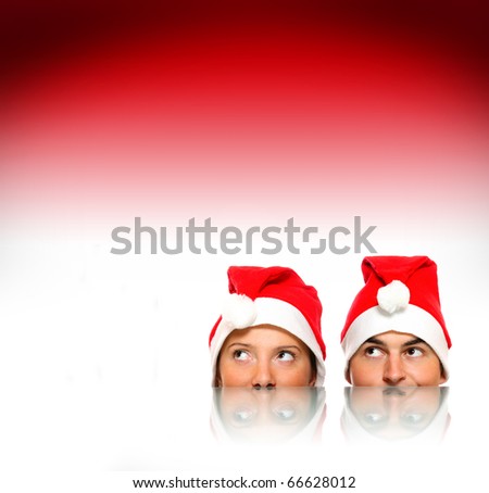 A picture of female and male Santas and their reflections over red background a lot of space for text